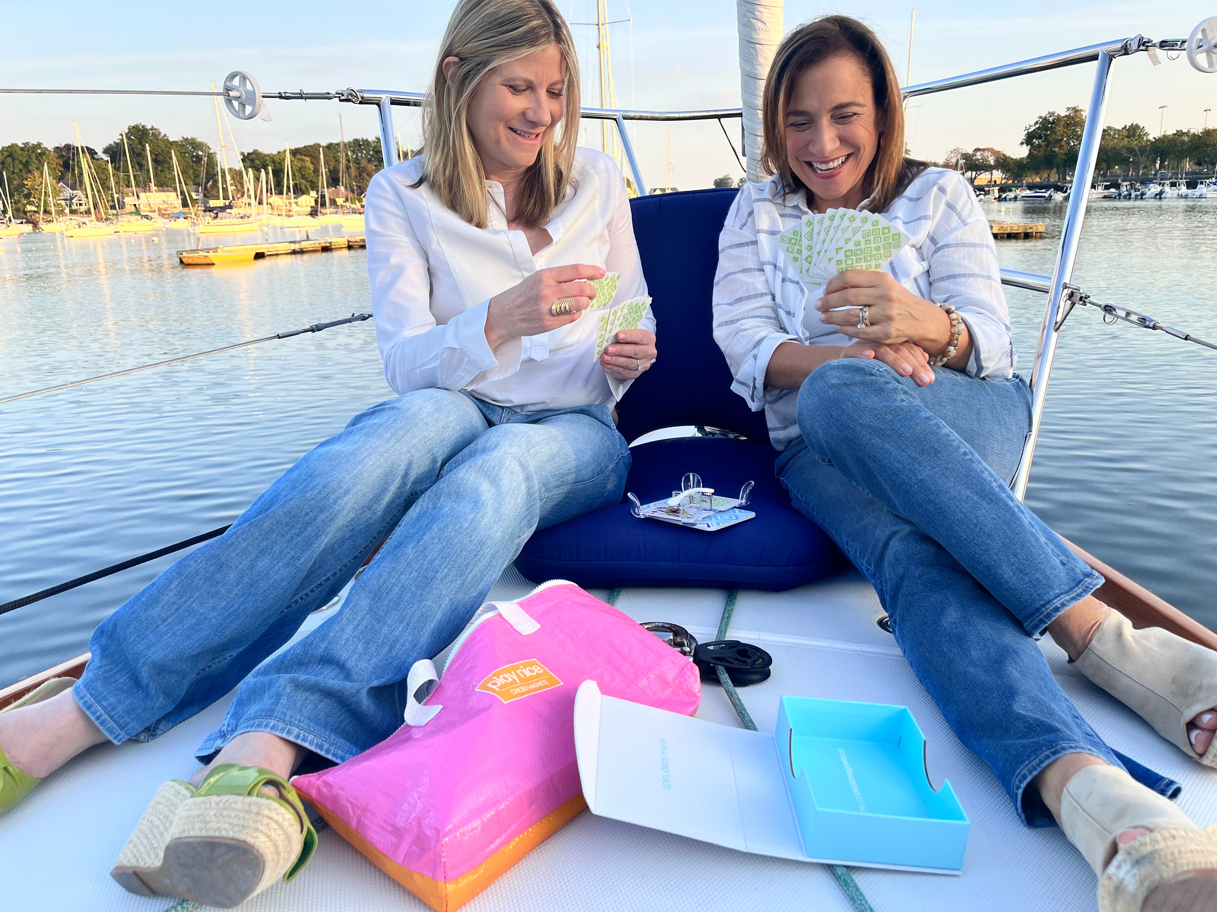 cofounders on a sailboat with the canasta traveler set and playing cards in an about us section.