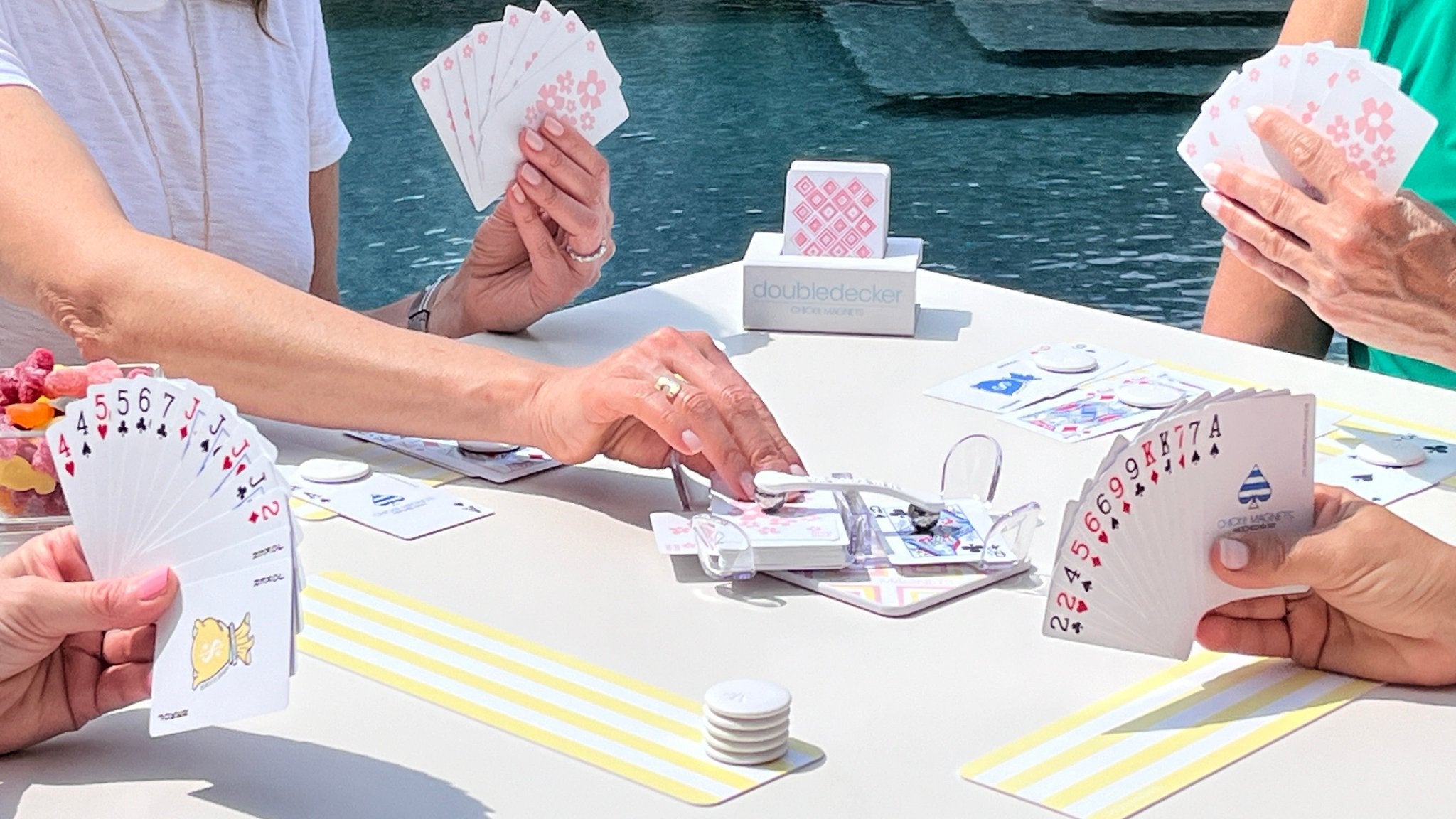 A Canasta game in progress with the Chick Magnets canasta traveler bundle designed to secure cards outdoors in wind.